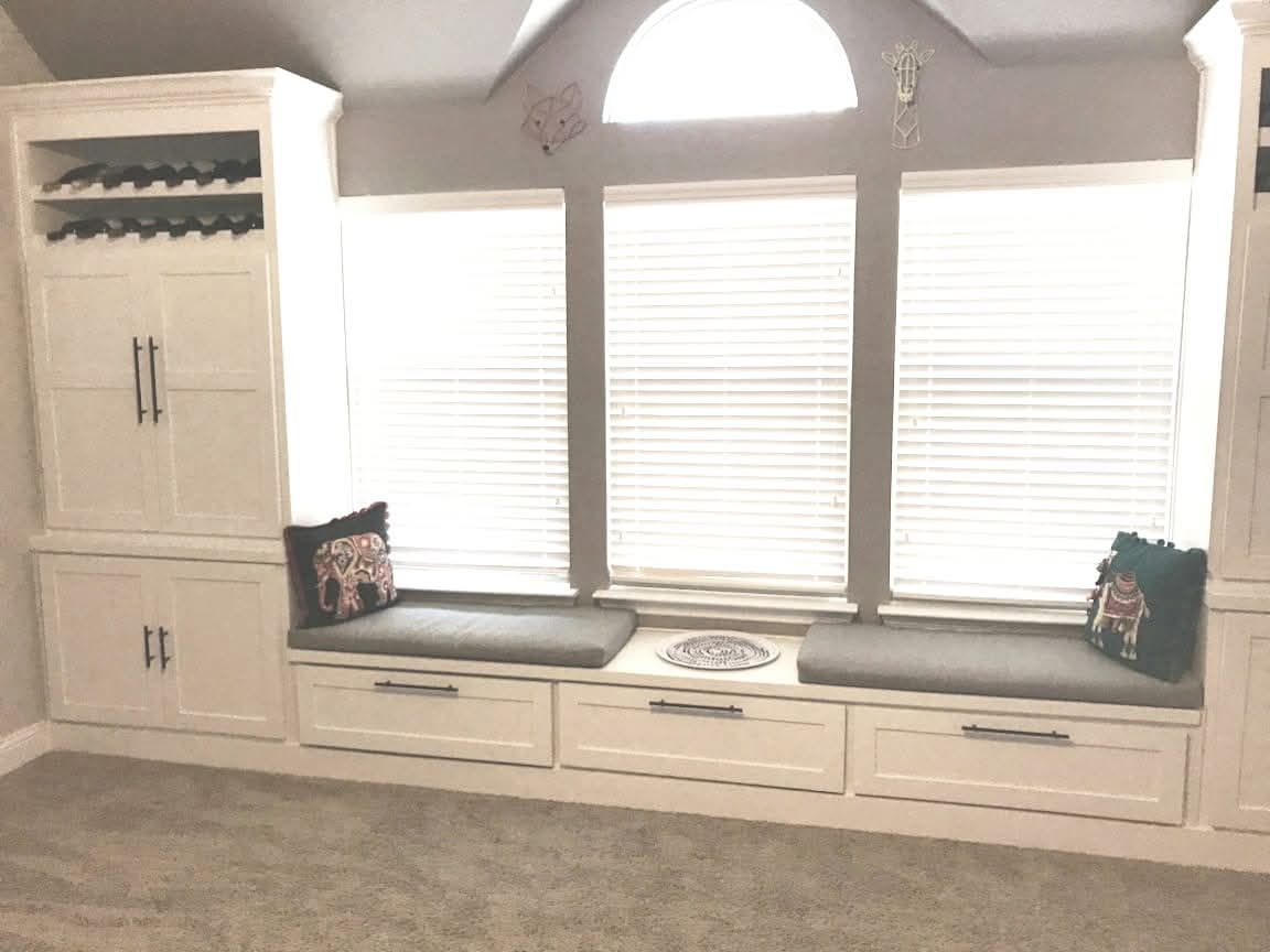 A window seat with drawers underneath it in a room