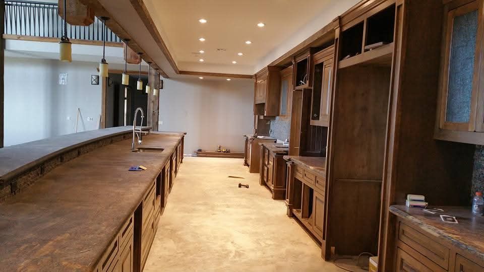 A kitchen with a long counter and wooden cabinets