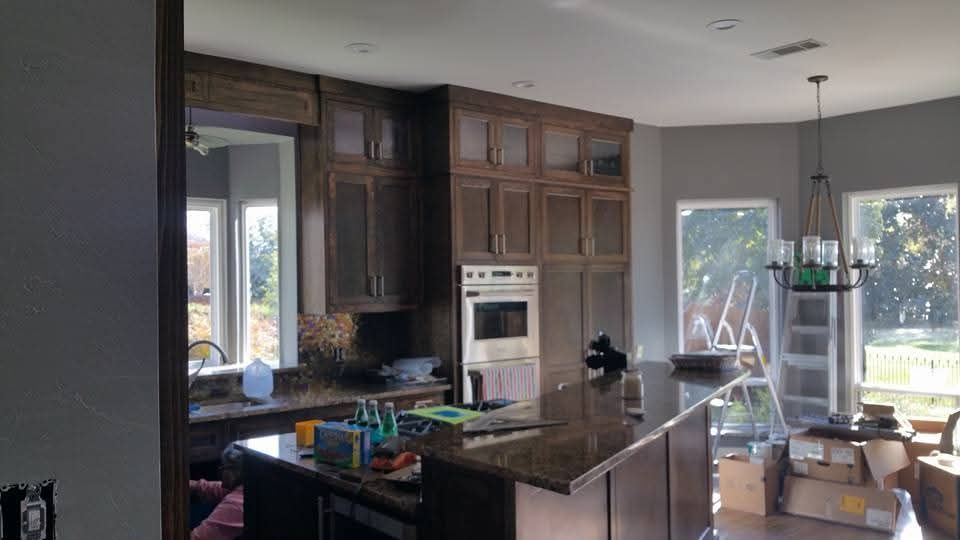 A kitchen with wooden cabinets , granite counter tops , stainless steel appliances , and a large island