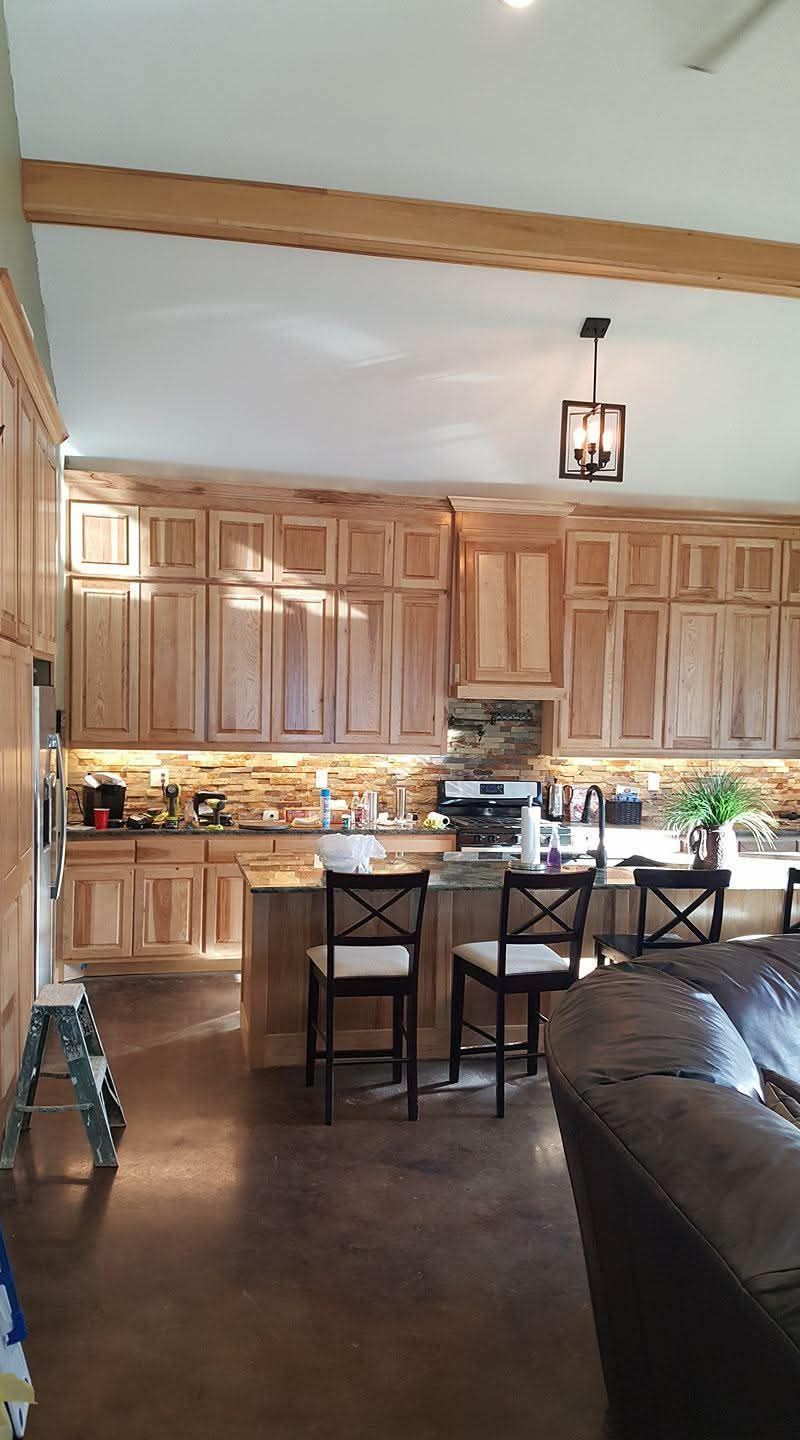 A kitchen with wooden cabinets and a living room with a couch
