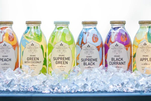 A row of bottles of juice are sitting on ice.