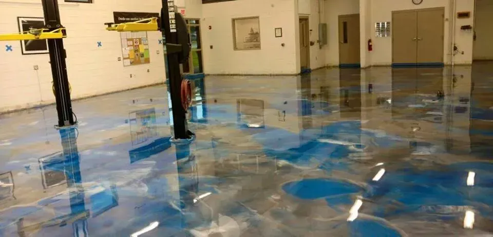 Indoor gym with a glossy blue floor and volleyball nets in the background