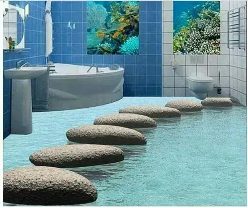 Modern bathroom with a blue-tiled floor, curved tub, sink, and stone stepping stones over water.