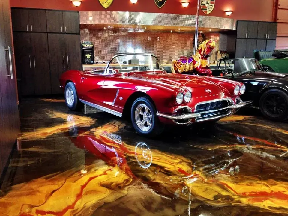 Red classic convertible sports car displayed in a glossy showroom with reflective floor.