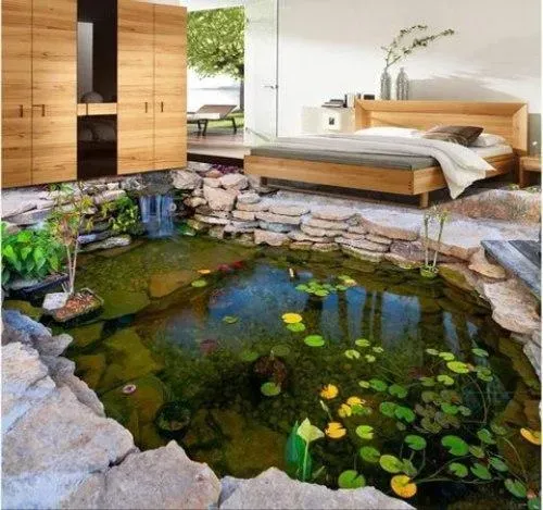 Modern bedroom with a wooden bed above an indoor koi pond and stone-lined water feature