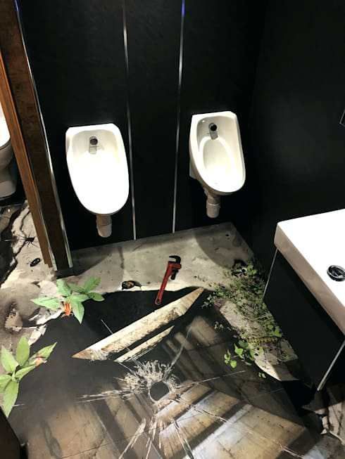 Flooded restroom with two wall urinals and standing water on the floor