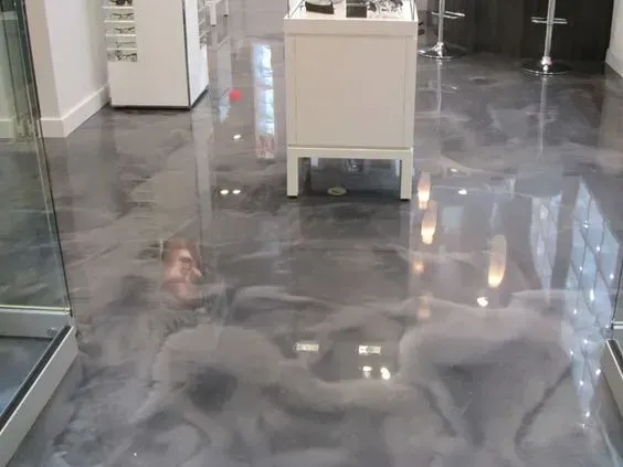 Two dogs on a glossy indoor floor near a small white cabinet and glass wall.