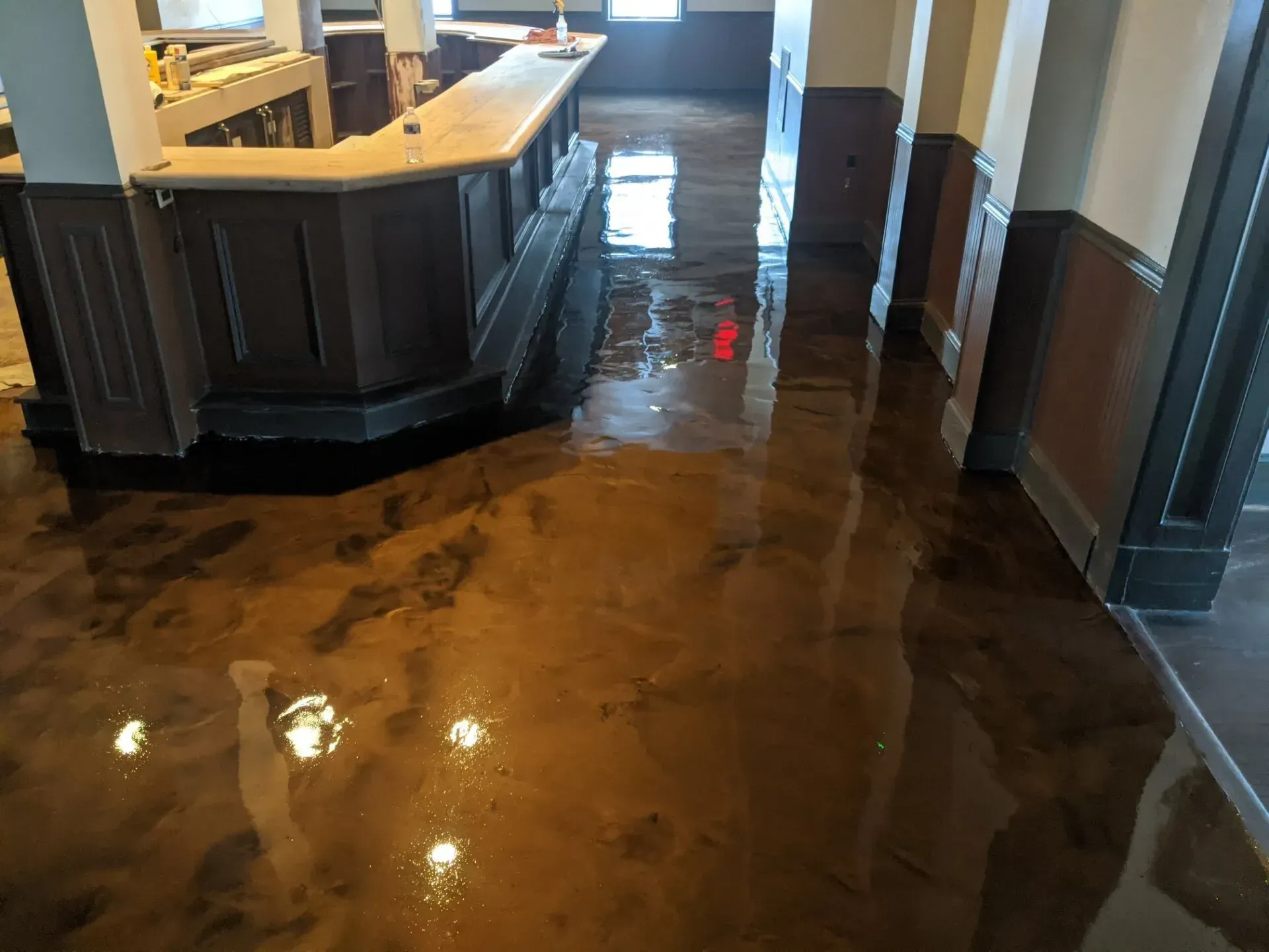 Lobby floor flooded with brown water around a curved reception desk