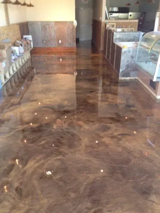 Empty café interior with glossy marbled floor and display cases along the sides