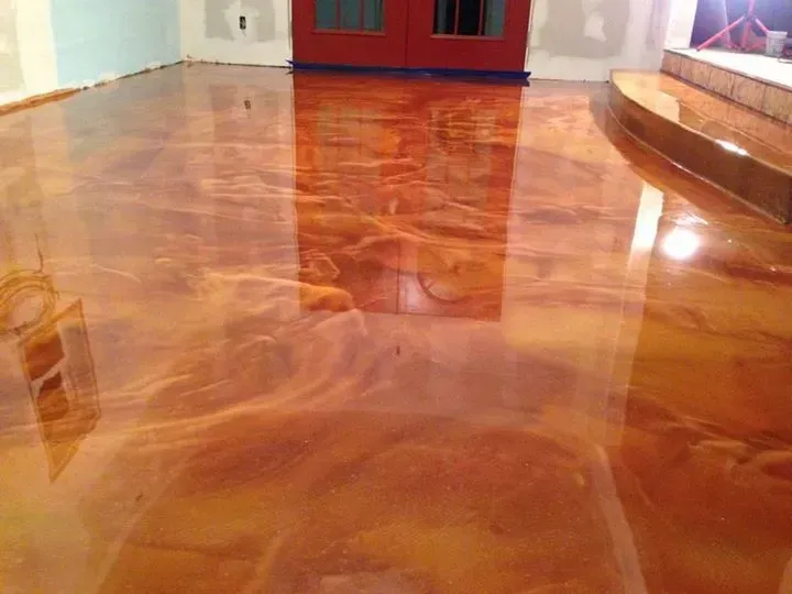 Glossy polished hardwood floor reflecting room light and red cabinet in the background