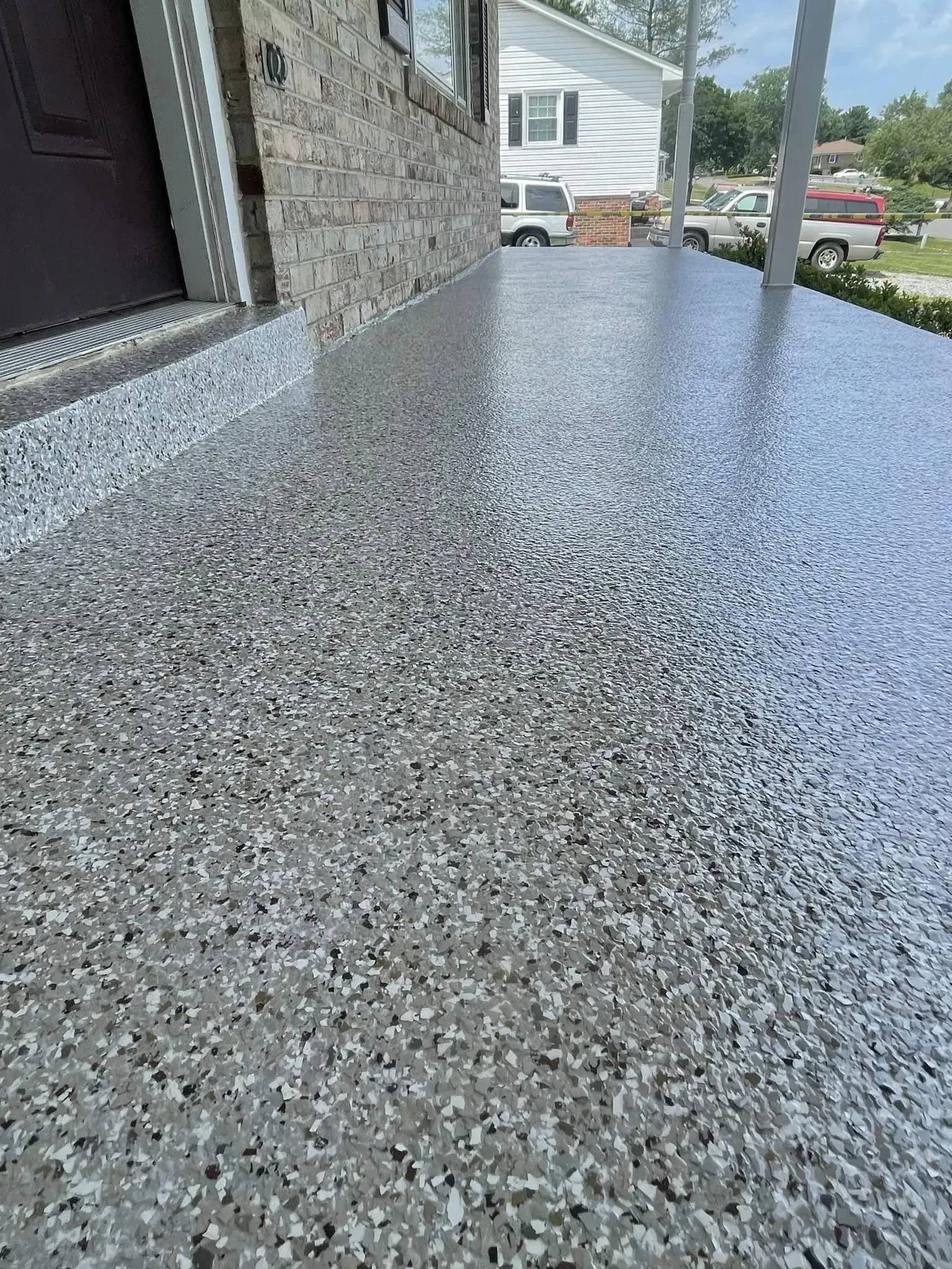 Speckled gray epoxy countertop extending beside a house exterior and window