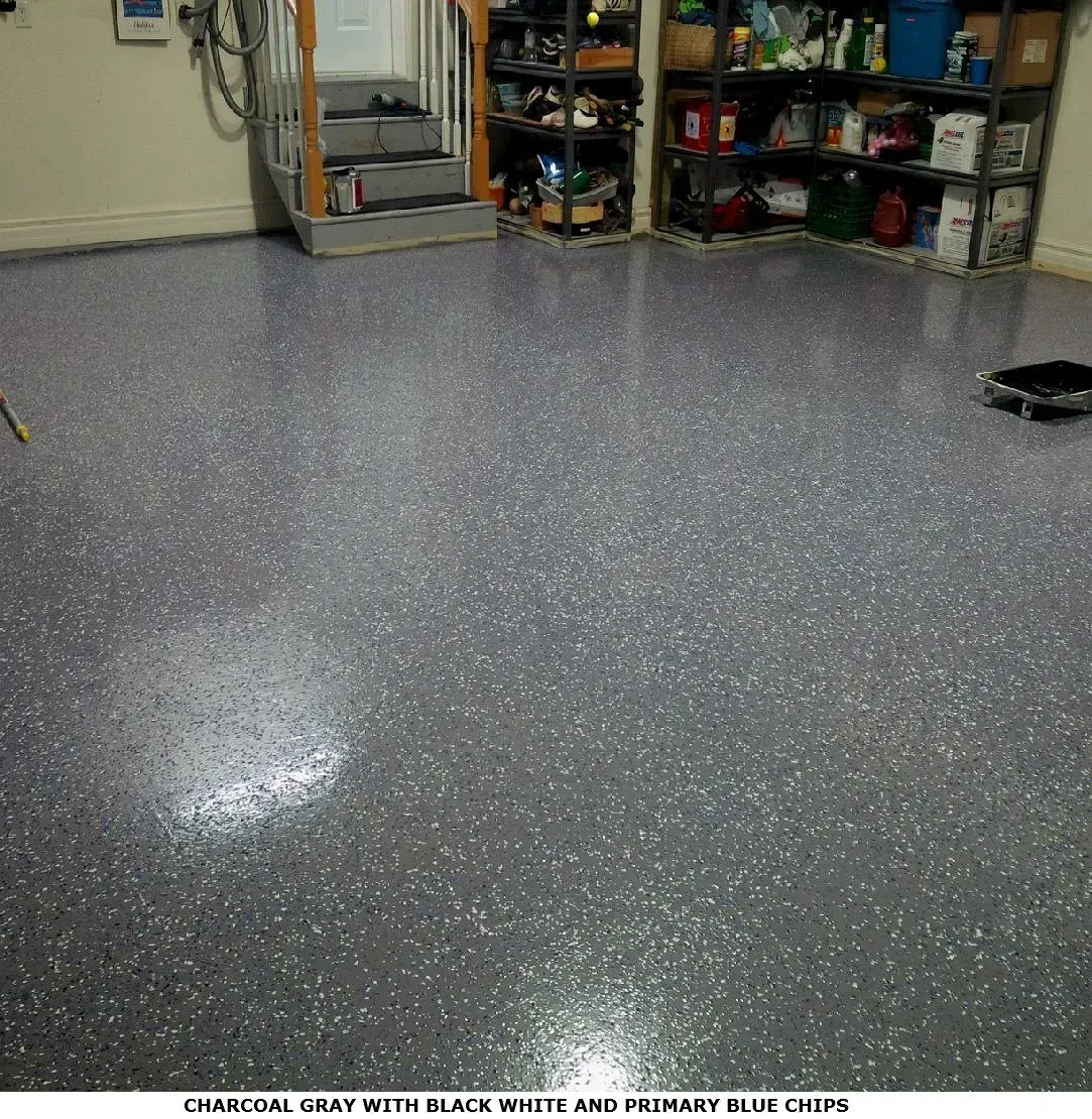 Empty speckled gray garage floor with shelves and storage bins along the back wall.