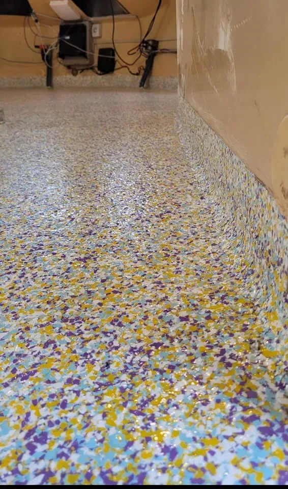 Speckled terrazzo floor hallway with tan walls and tables at the far end