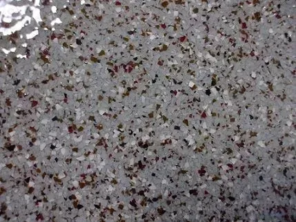 Gray-speckled textured surface with scattered dark and reddish flecks