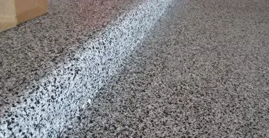 Close-up of a speckled gray concrete surface with a white painted line