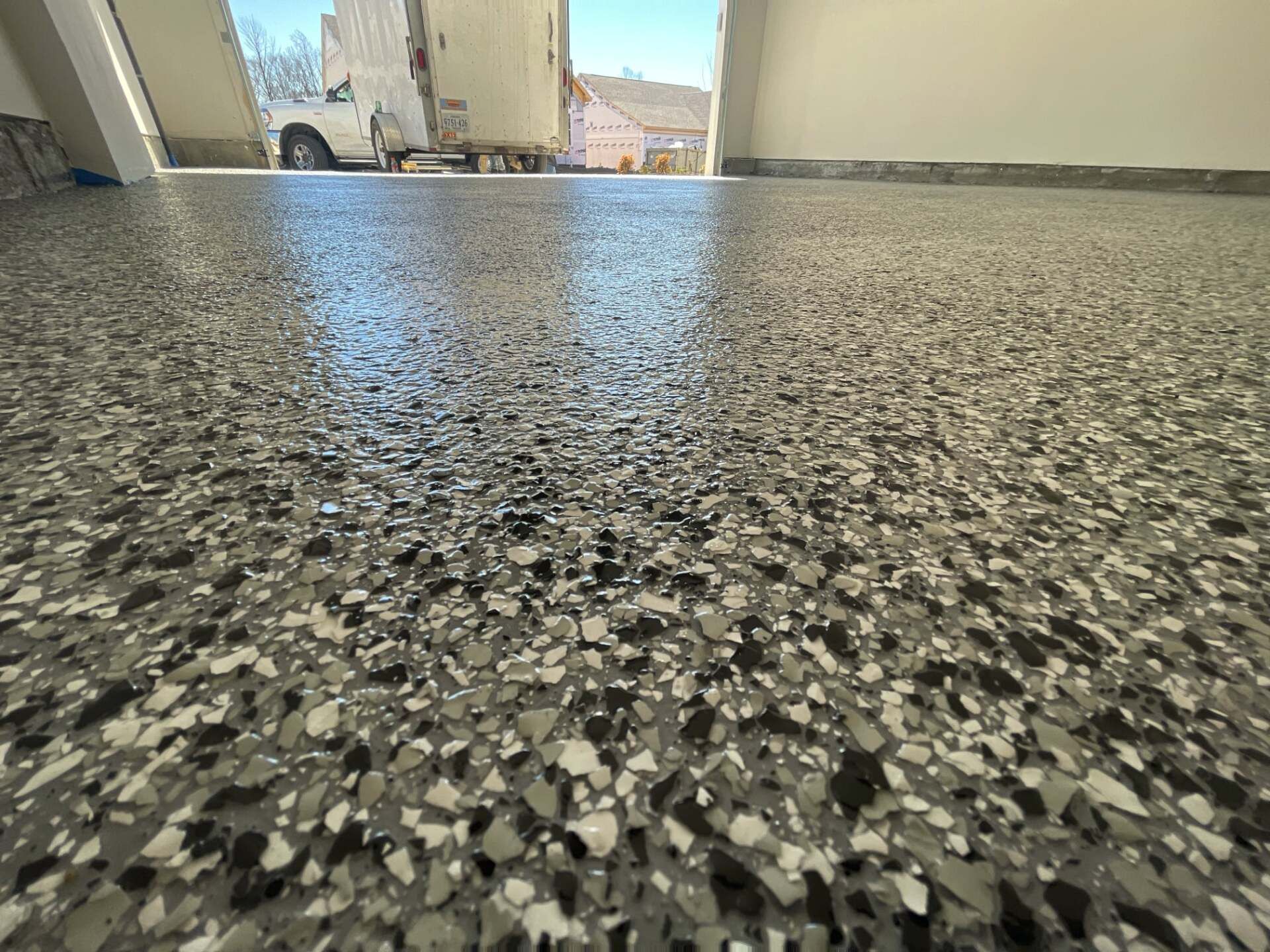 Speckled gray terrazzo floor in a bright indoor walkway with daylight at the far end
