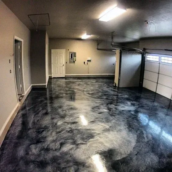 Empty garage with glossy black and gray marbled floor and white walls.