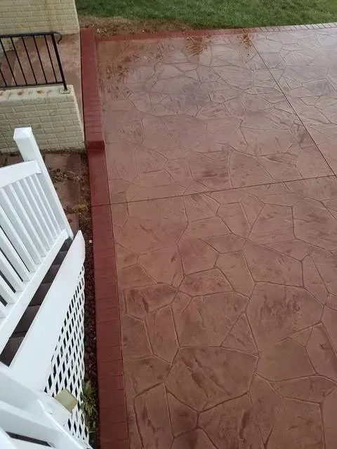 White railing beside a red-tiled patio and walkway, viewed from above