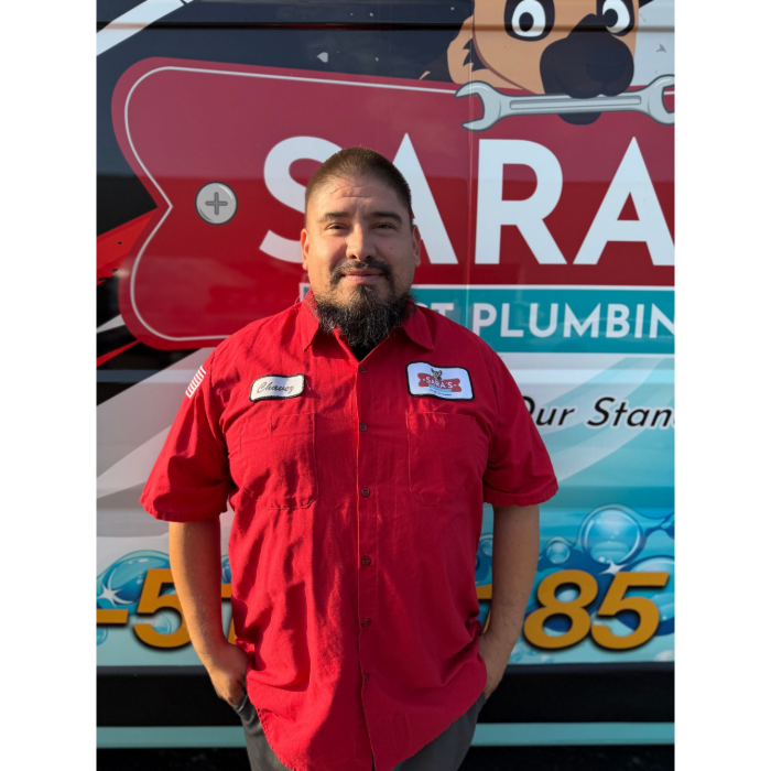 Smiling man with brown hair in a light blue button-up shirt.