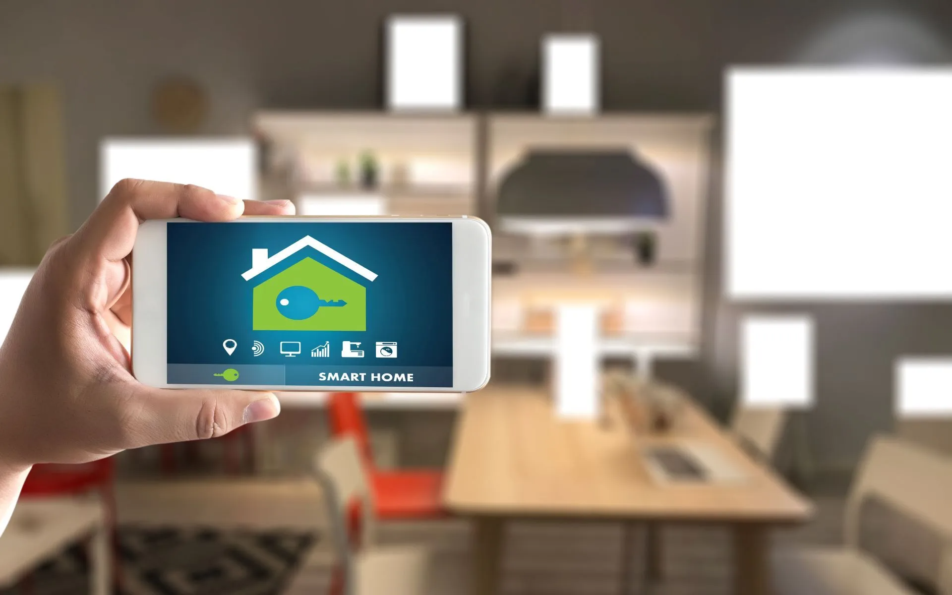 Hand holding a phone displaying a smart home app interface in a modern kitchen.