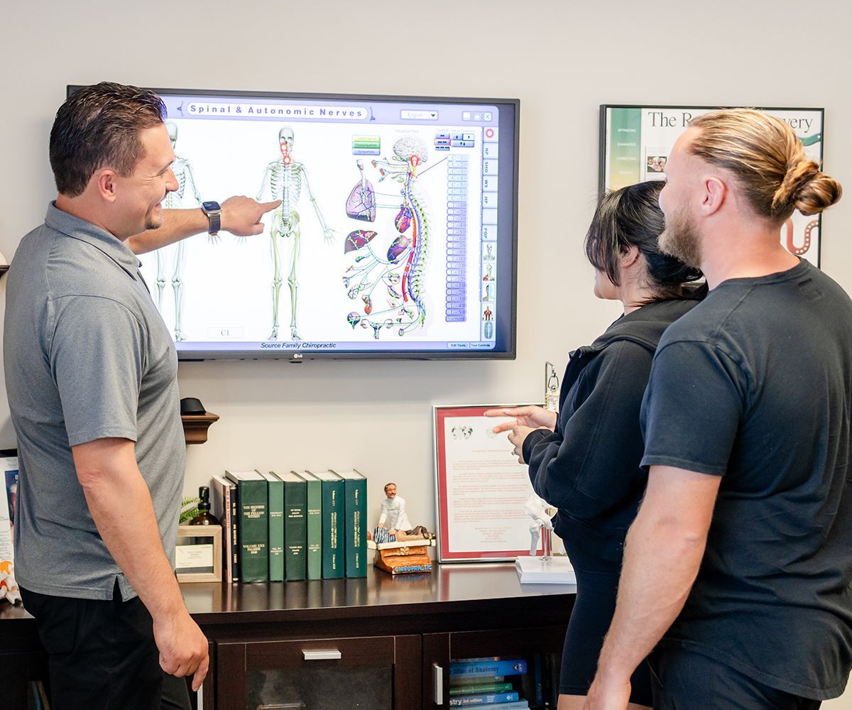 A man is pointing at a screen with a picture of a skeleton on it