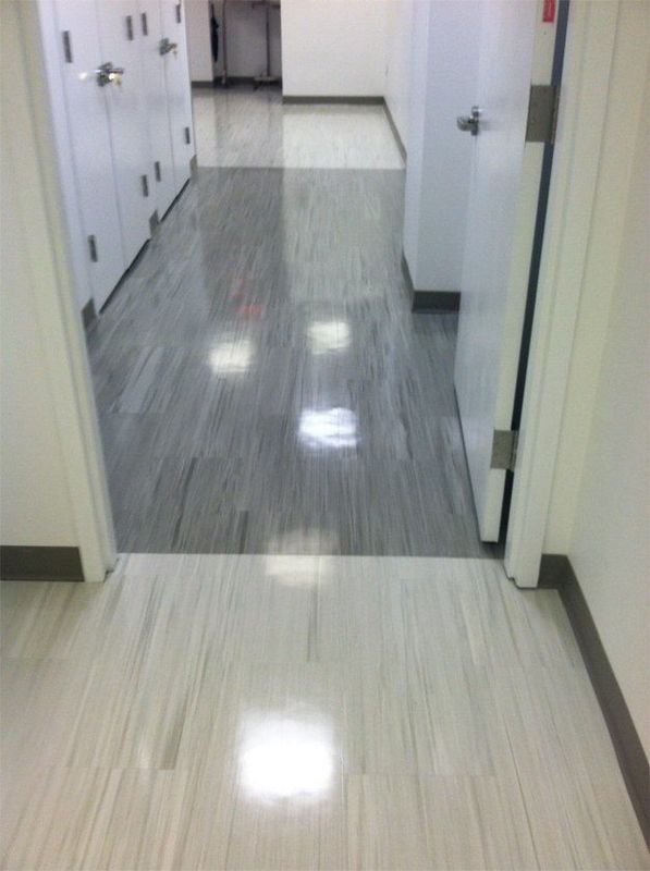 Empty hospital hallway with shiny gray floor and white doors