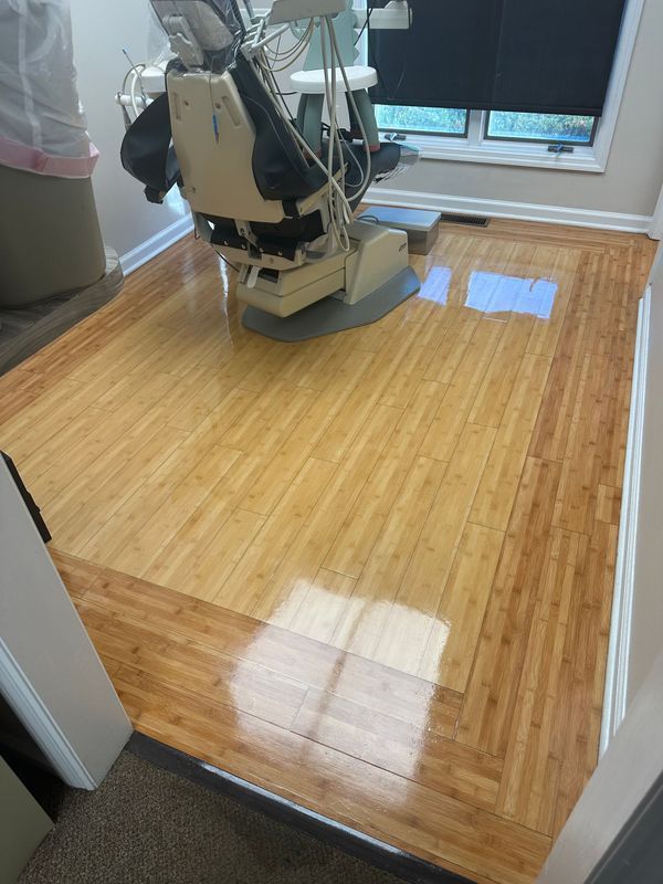 Floor sander polishing a glossy wooden hallway floor near windows