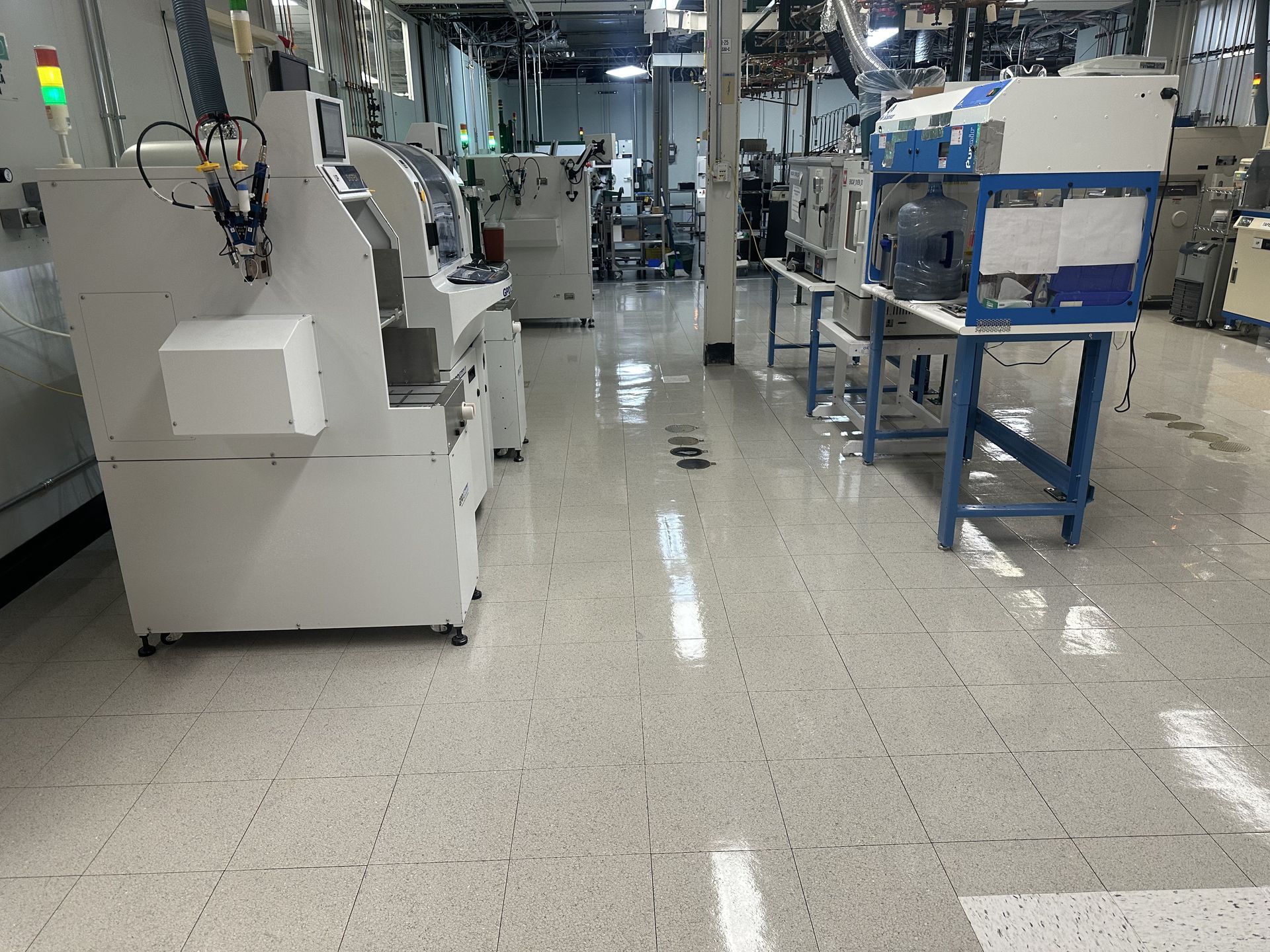 Industrial factory aisle with machines, metal frames, and boxes on a polished floor