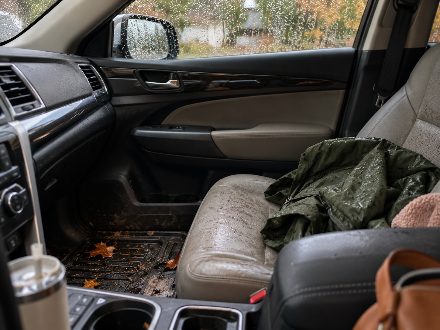 Rainy fall car interior with wet seats, muddy floor mats and leaves in Bellingham, WA.