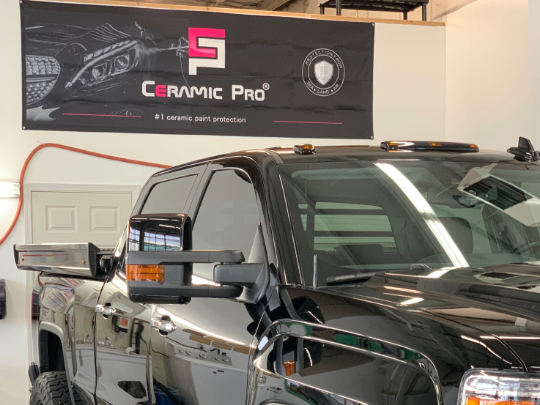 Black truck with tinted windows, parked inside under a 