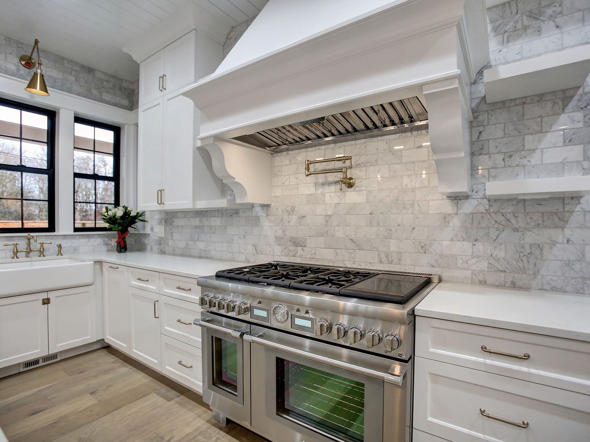 A kitchen with stainless steel appliances and white cabinets.