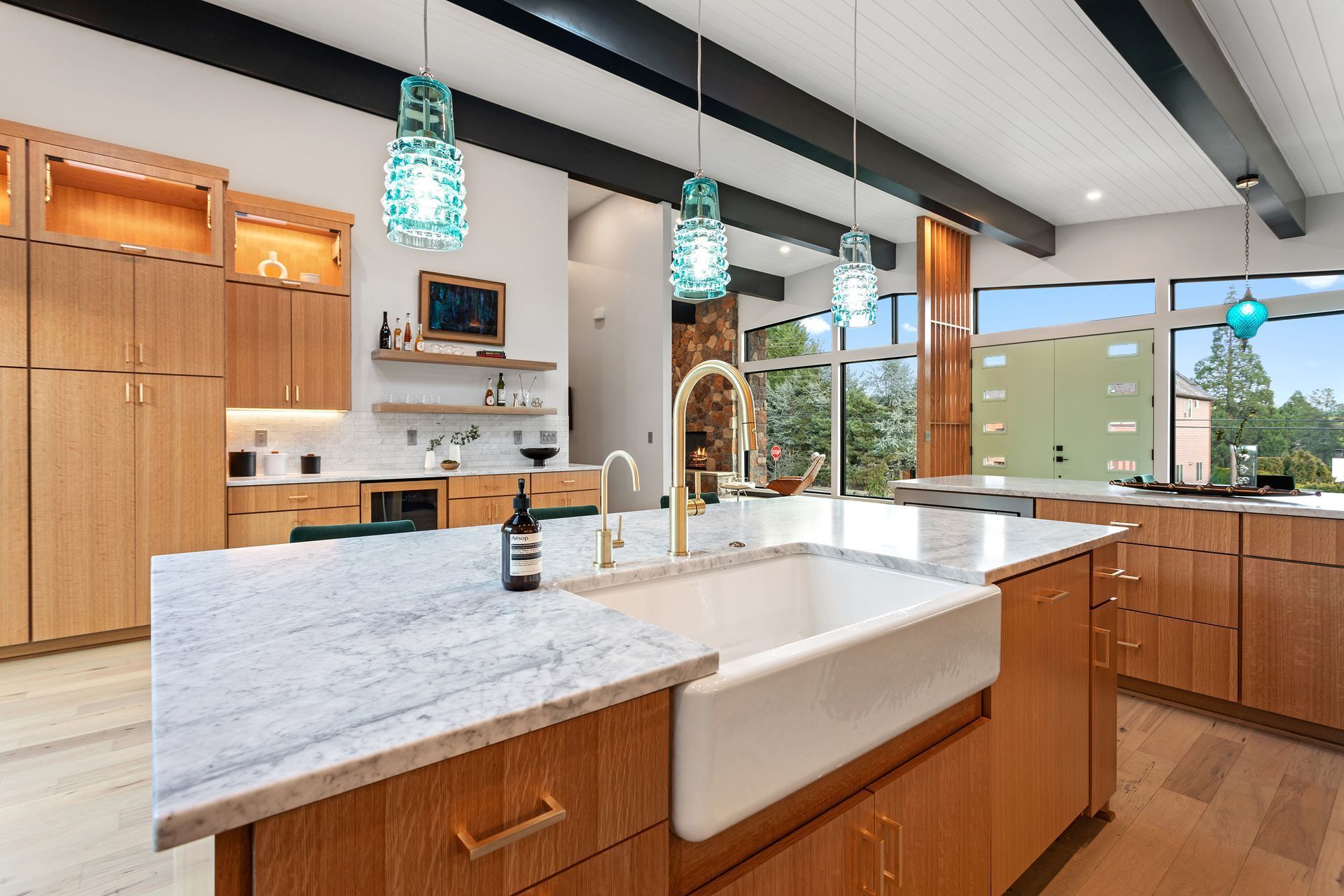 A kitchen with a large sink and a marble counter top.