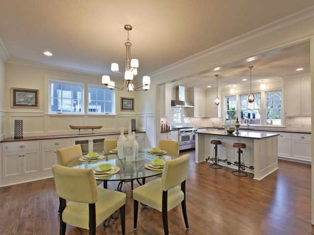 A kitchen and dining room with a glass table and chairs