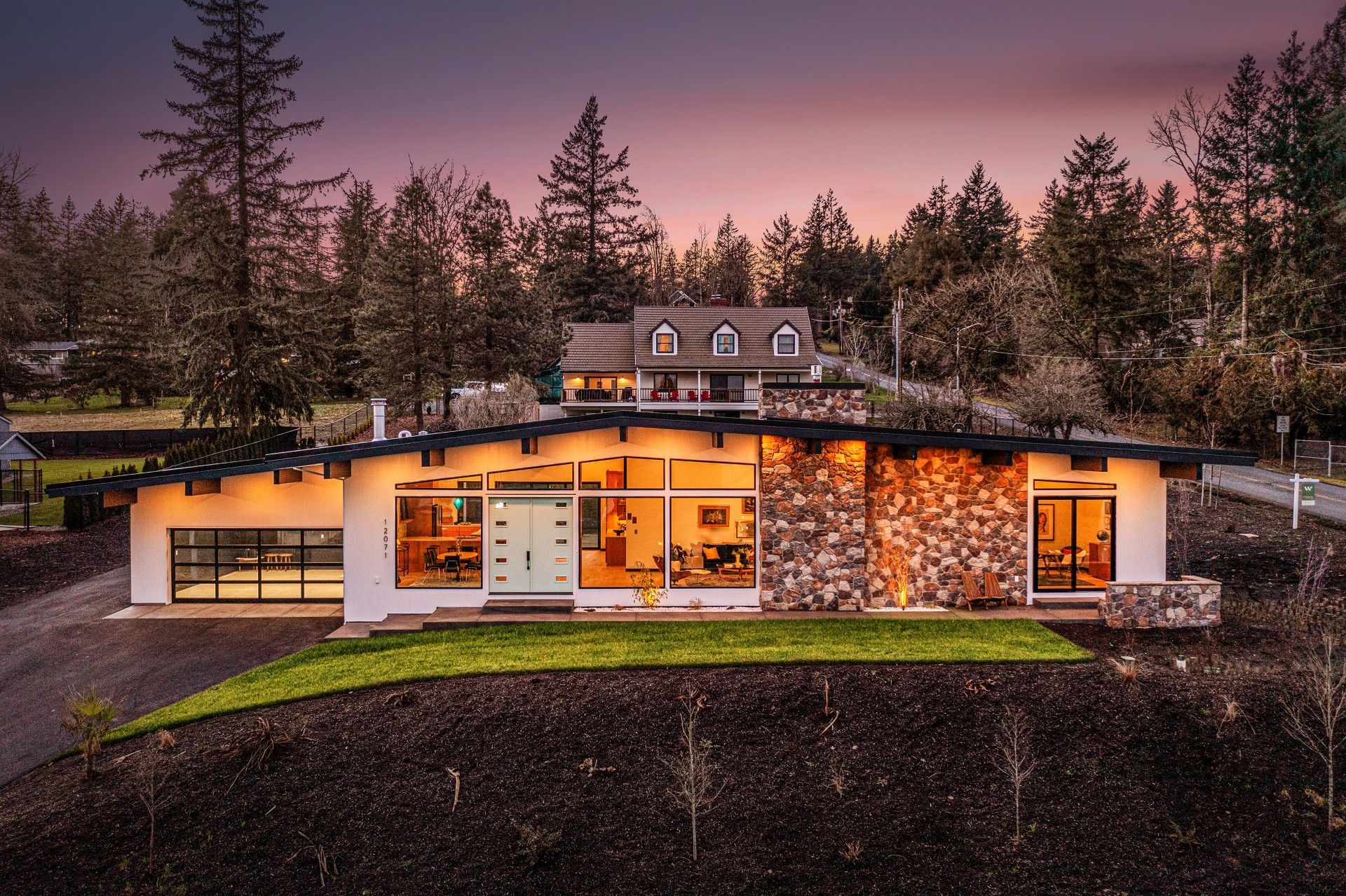 A large house with a lot of windows is surrounded by trees