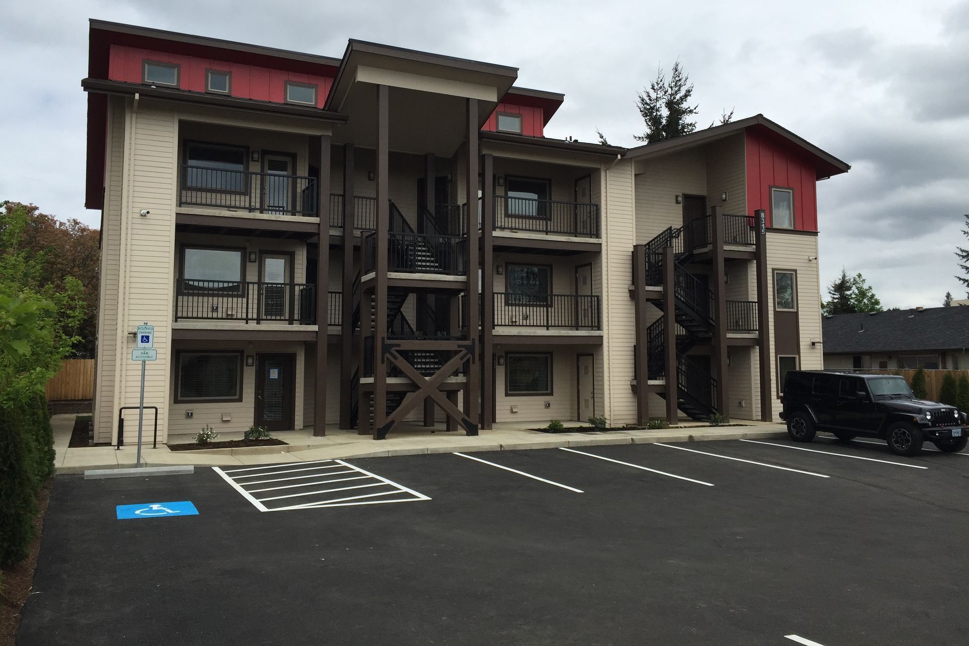 A jeep is parked in front of a large apartment building