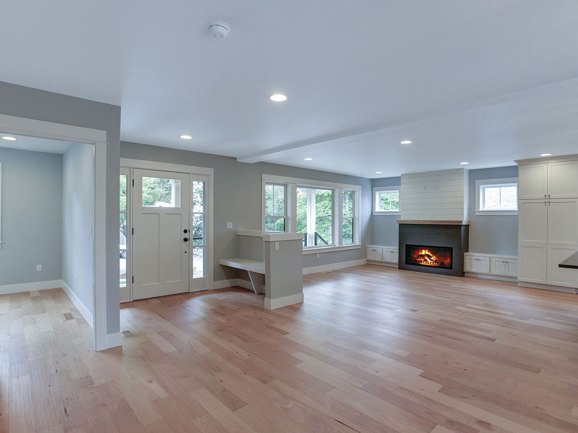 An empty living room with hardwood floors and a fireplace
