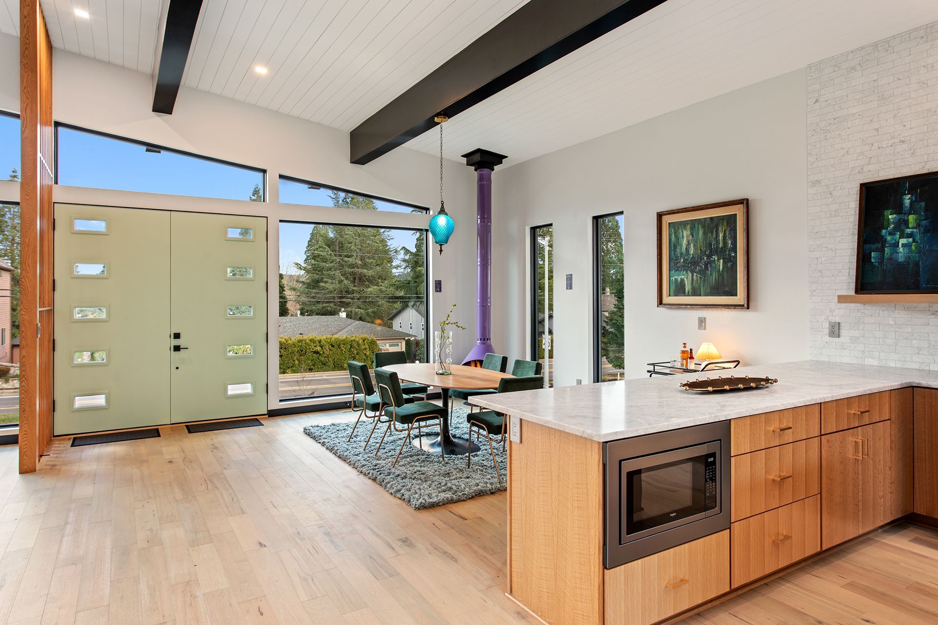 A kitchen and dining room in a house with a large island in the middle