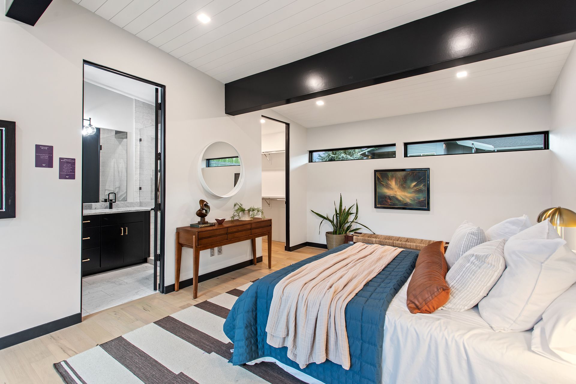 A bedroom with a large bed and a black beams on the ceiling