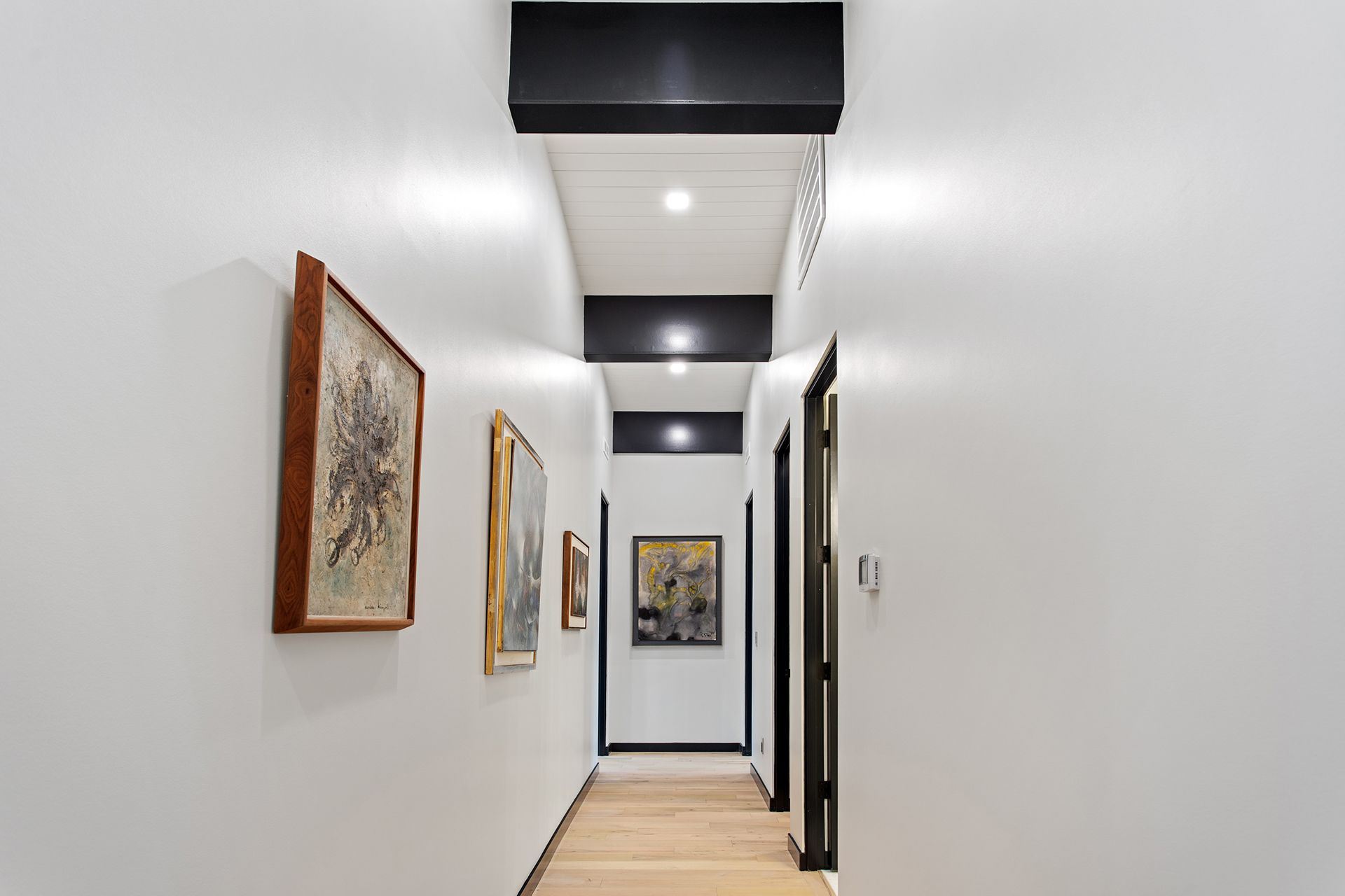 A long hallway with paintings hanging on the wall