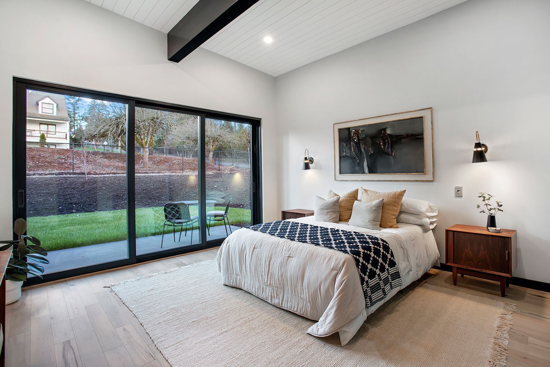 A bedroom with a large bed and sliding glass doors