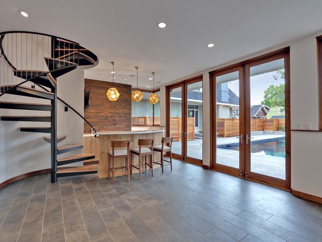 A living room with a spiral staircase and sliding glass doors