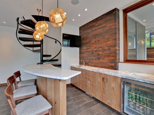 A kitchen with a spiral staircase and a bar