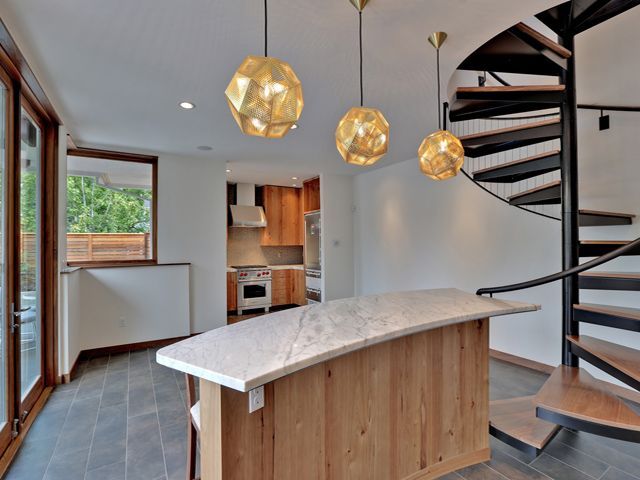 A kitchen with a wooden island and a spiral staircase