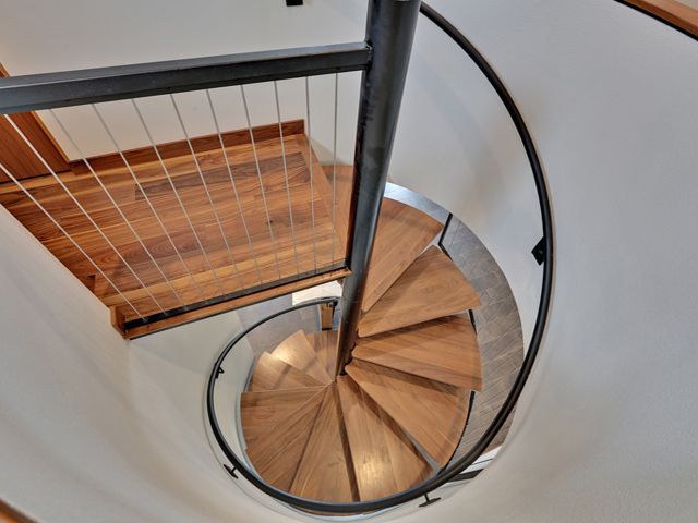 A spiral staircase with wooden steps and a metal railing