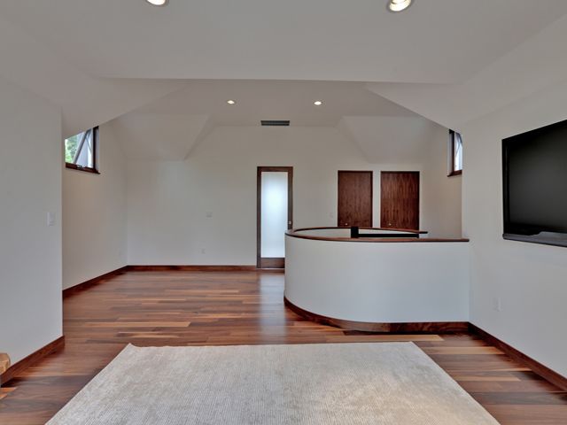 An empty room with hardwood floors and a flat screen TV