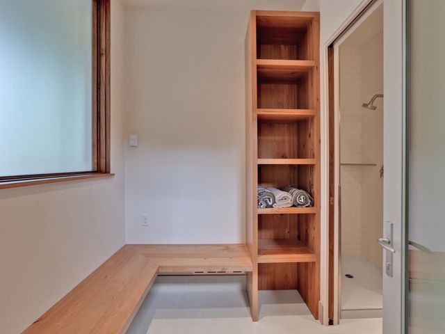 A bathroom with a wooden bench and shelves