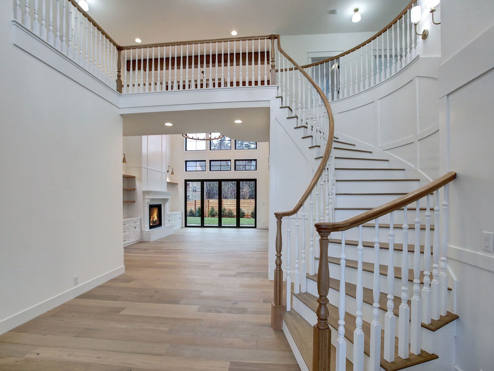A curved staircase in an empty house with a wooden railing