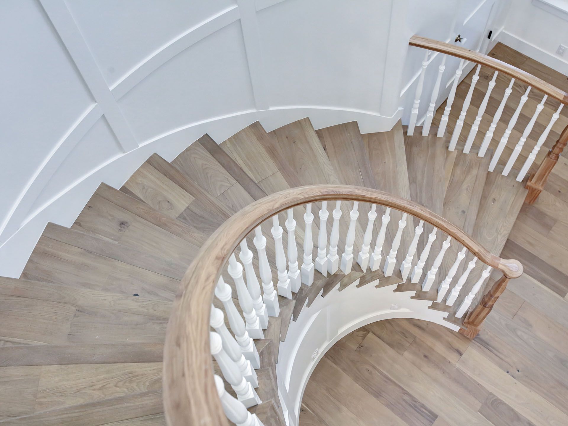 A spiral staircase with wooden steps and white railings