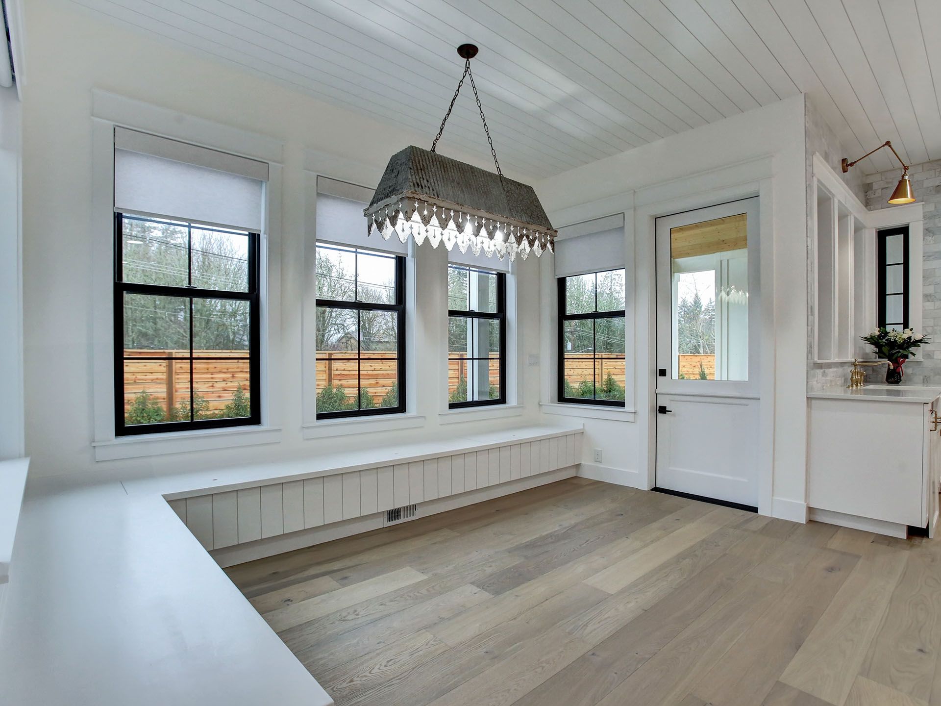 A room with a lot of windows and a chandelier hanging from the ceiling