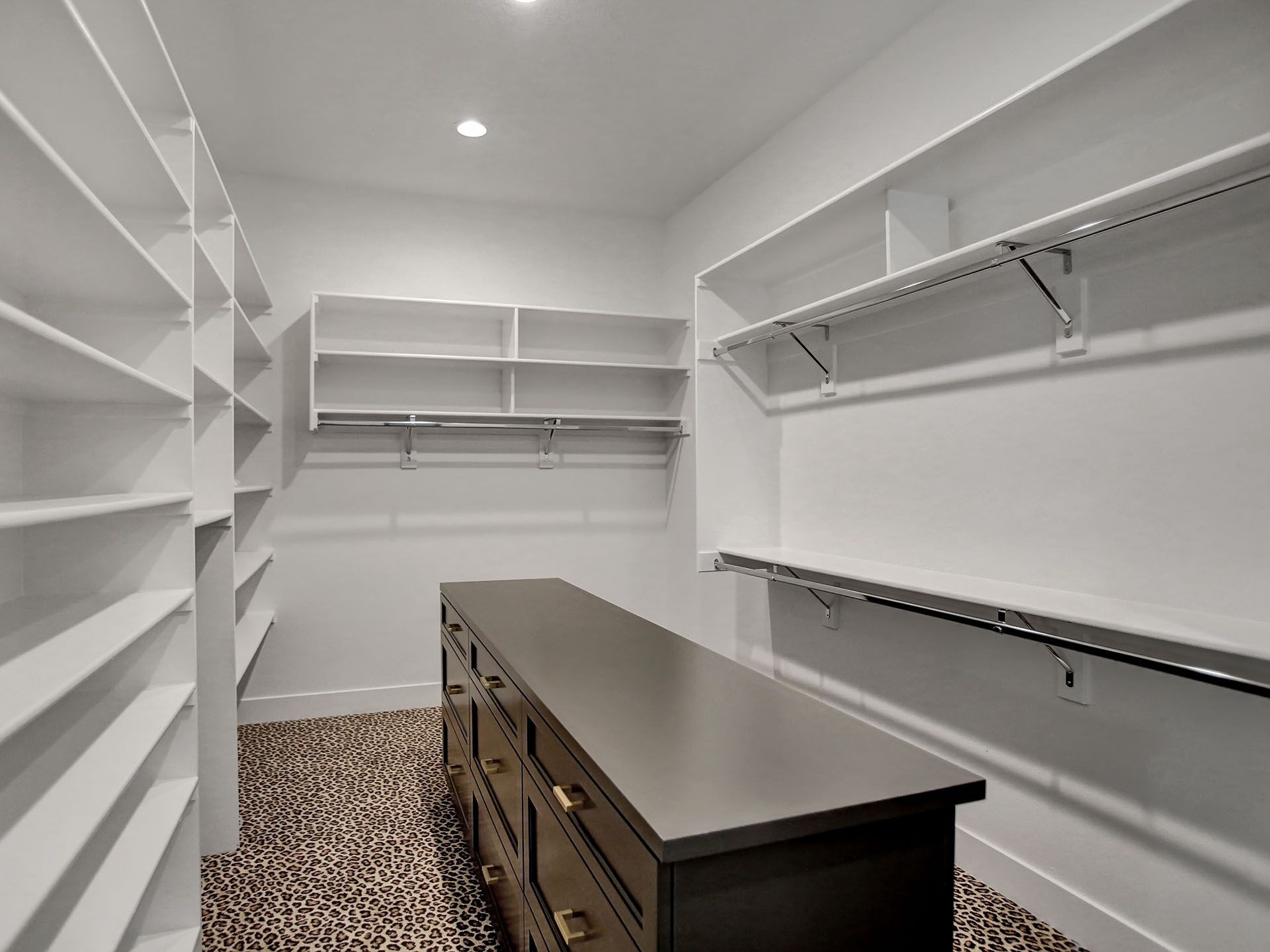 A walk-in closet with lots of shelves and a dresser